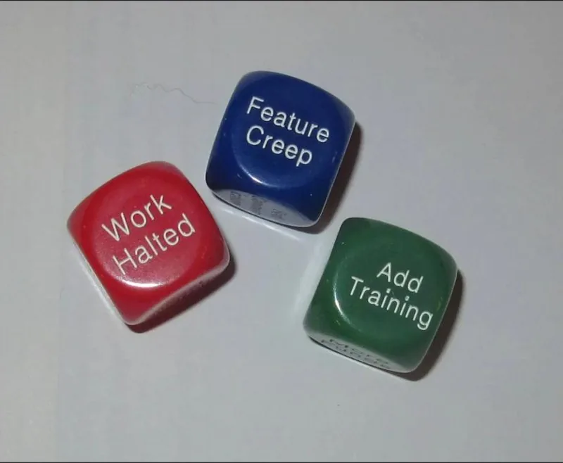 Three dice reading Feature Creep, Work Halted and Add Training