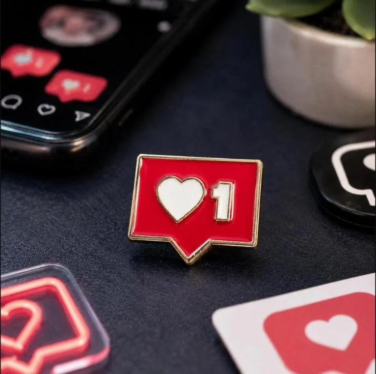 Red enamel pin of a like notification showing one heart