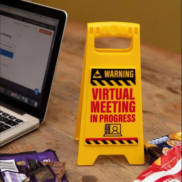 Small yellow warning sign reading Virtual Meeting In Progress